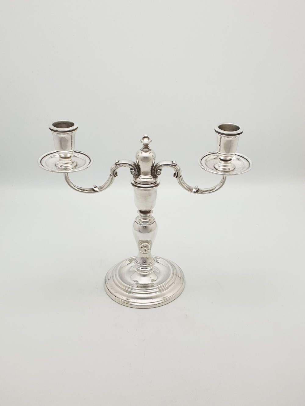 A pair of silver-plated low two-branch candelabra featuring turned central stems, circular stepped bases, and scrolled arms. View III