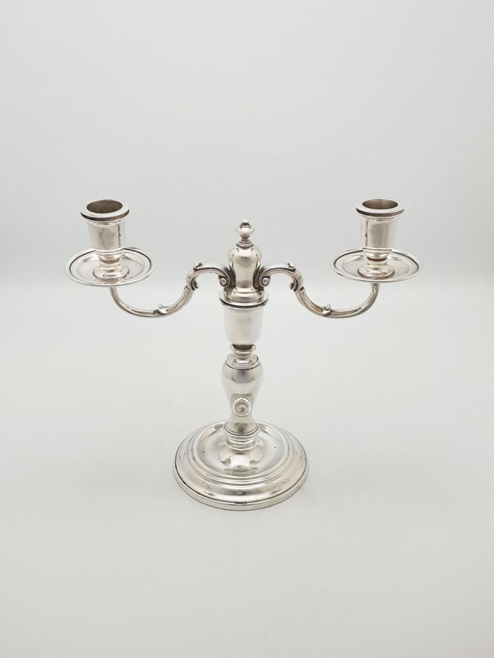A pair of silver-plated low two-branch candelabra featuring turned central stems, circular stepped bases, and scrolled arms. View VI