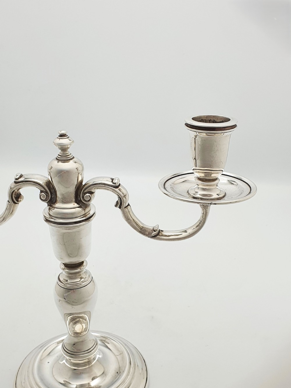 A pair of silver-plated low two-branch candelabra featuring turned central stems, circular stepped bases, and scrolled arms. View IX