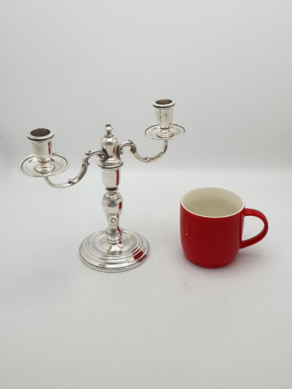 A pair of silver-plated low two-branch candelabra featuring turned central stems, circular stepped bases, and scrolled arms. View X