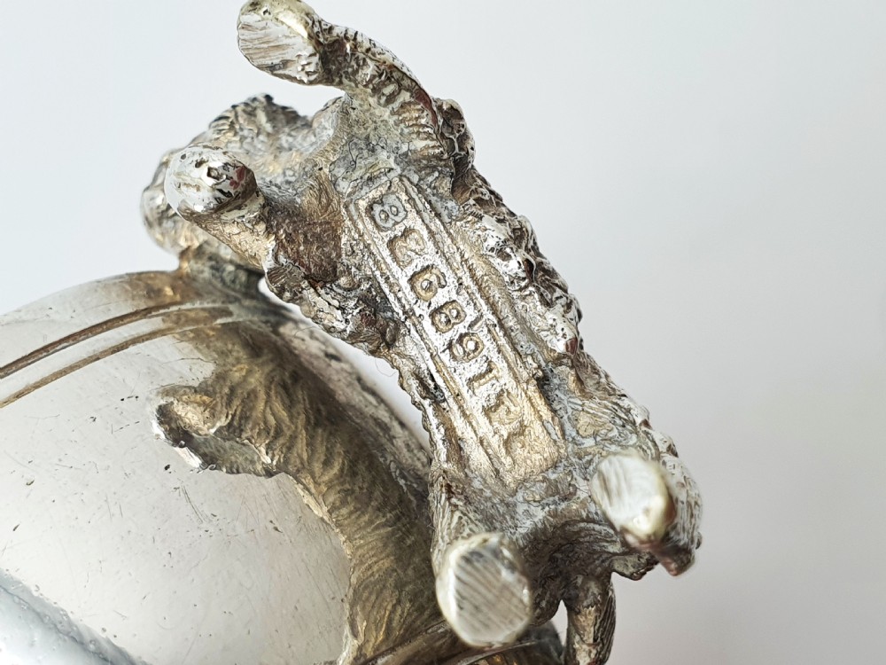 A pair of Victorian silver-plated napkin rings featuring detailed cast figures of young girls wearing bonnets standing beside engraved circular rings. View VIII