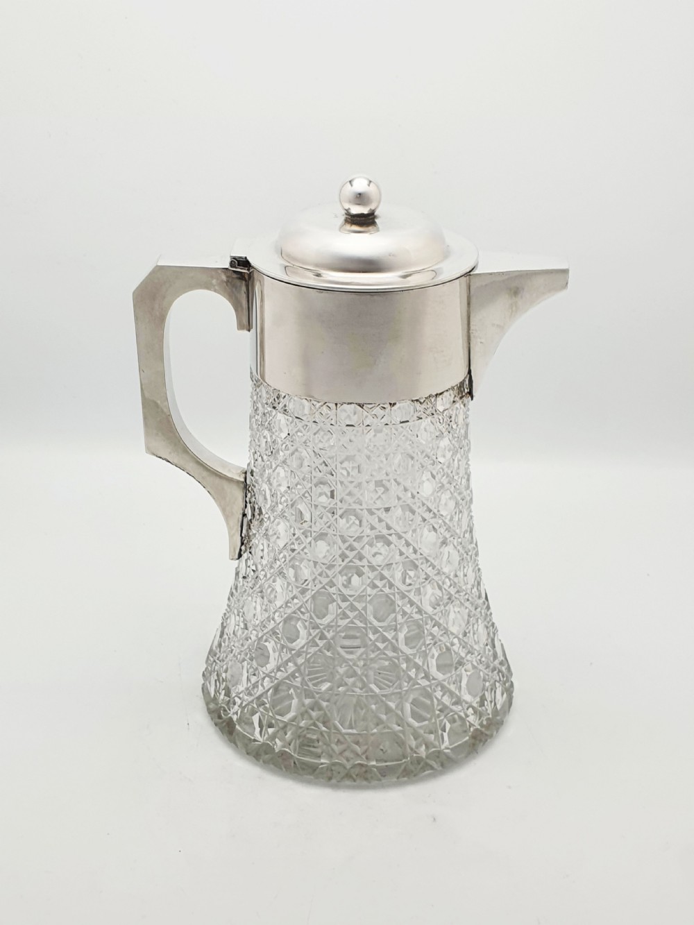 An antique Victorian cut glass lemonade jug featuring a silver-plated hinged lid and spout alongside its removable clear glass ice tube insert. View VI