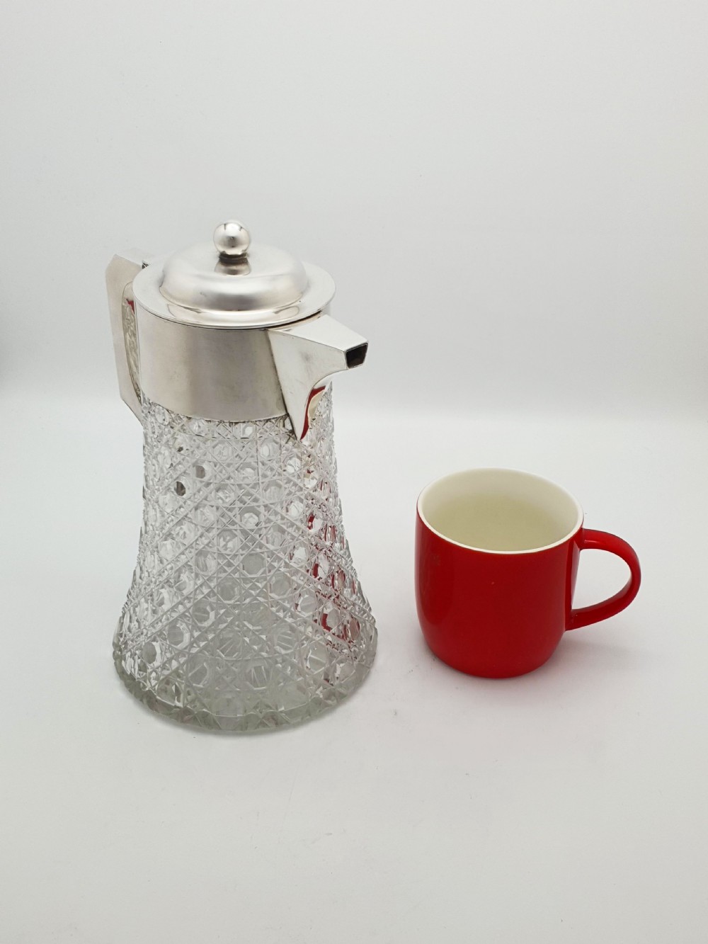An antique Victorian cut glass lemonade jug featuring a silver-plated hinged lid and spout alongside its removable clear glass ice tube insert. View XII