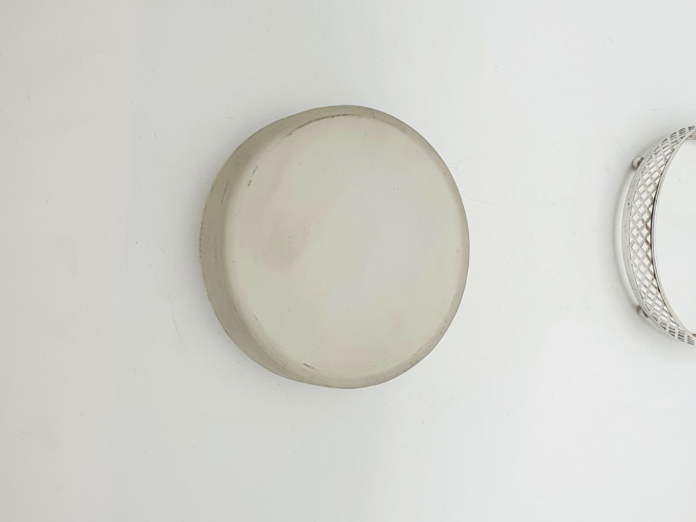 A circular sterling silver dish with a pierced lattice pattern, raised on small ball feet, fitted with a clear glass insert. View III