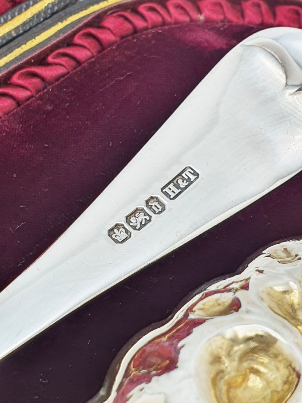 A pair of Victorian sterling silver berry spoons with embossed gilt fruit bowls and engraved handles, presented in a fitted velvet-lined case. View IV