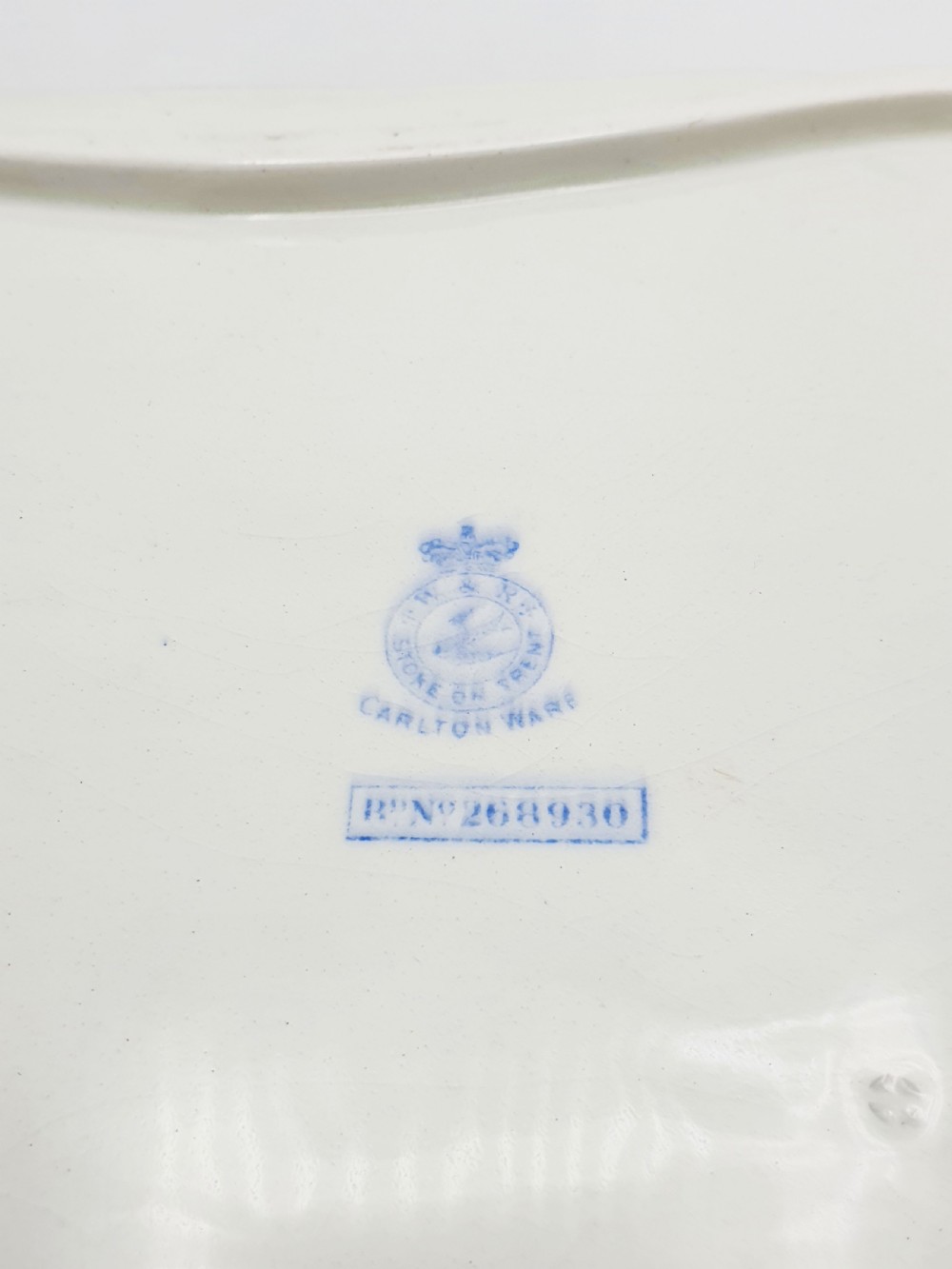 A rectangular cream ceramic tray with a central floral motif and gilded relief border. View VIII