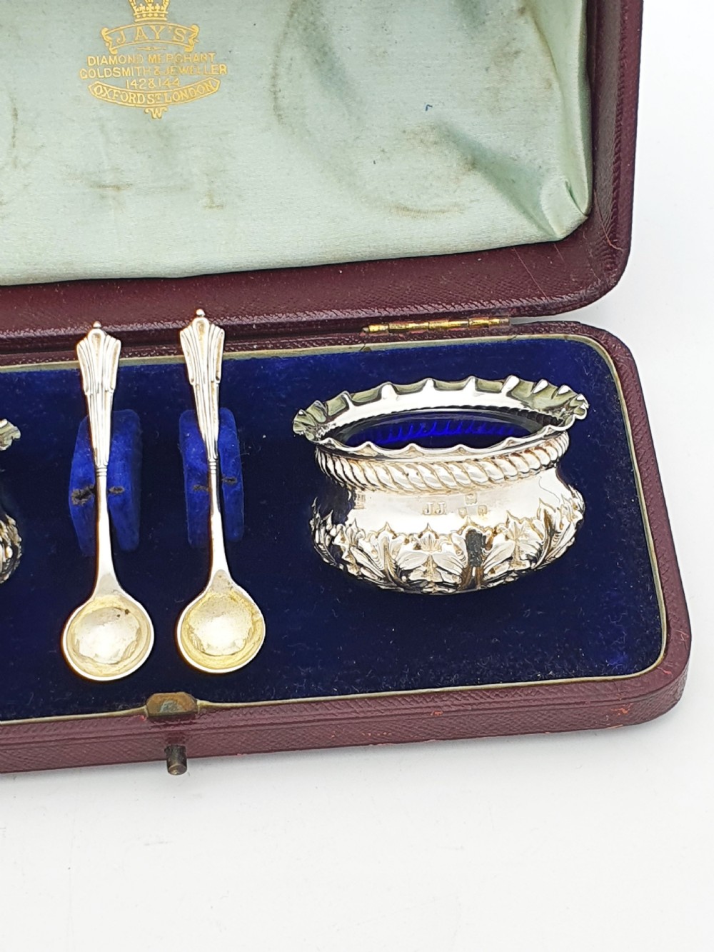 A pair of Victorian sterling silver open salt cellars with repousse leaf decoration and matching silver spoons in a velvet-lined maroon fitted box. View III