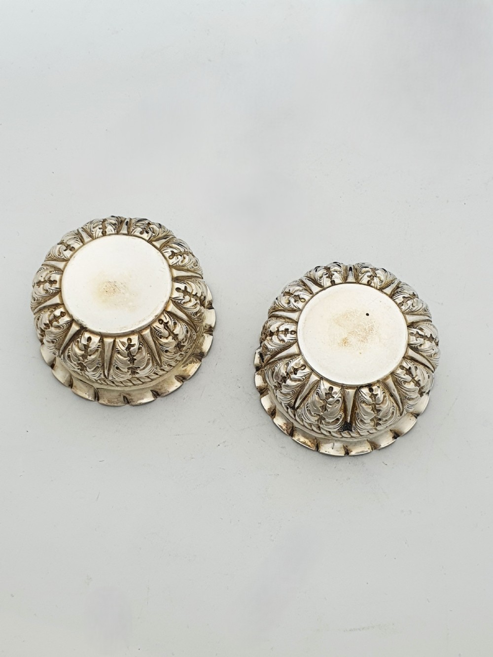 A pair of Victorian sterling silver open salt cellars with repousse leaf decoration and matching silver spoons in a velvet-lined maroon fitted box. View VII