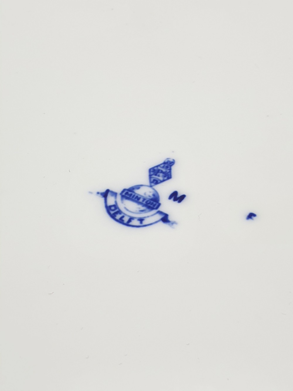 An elongated diamond-shaped white porcelain tray decorated with blue floral transfers, a central floral basket motif, and gilded handles. View V