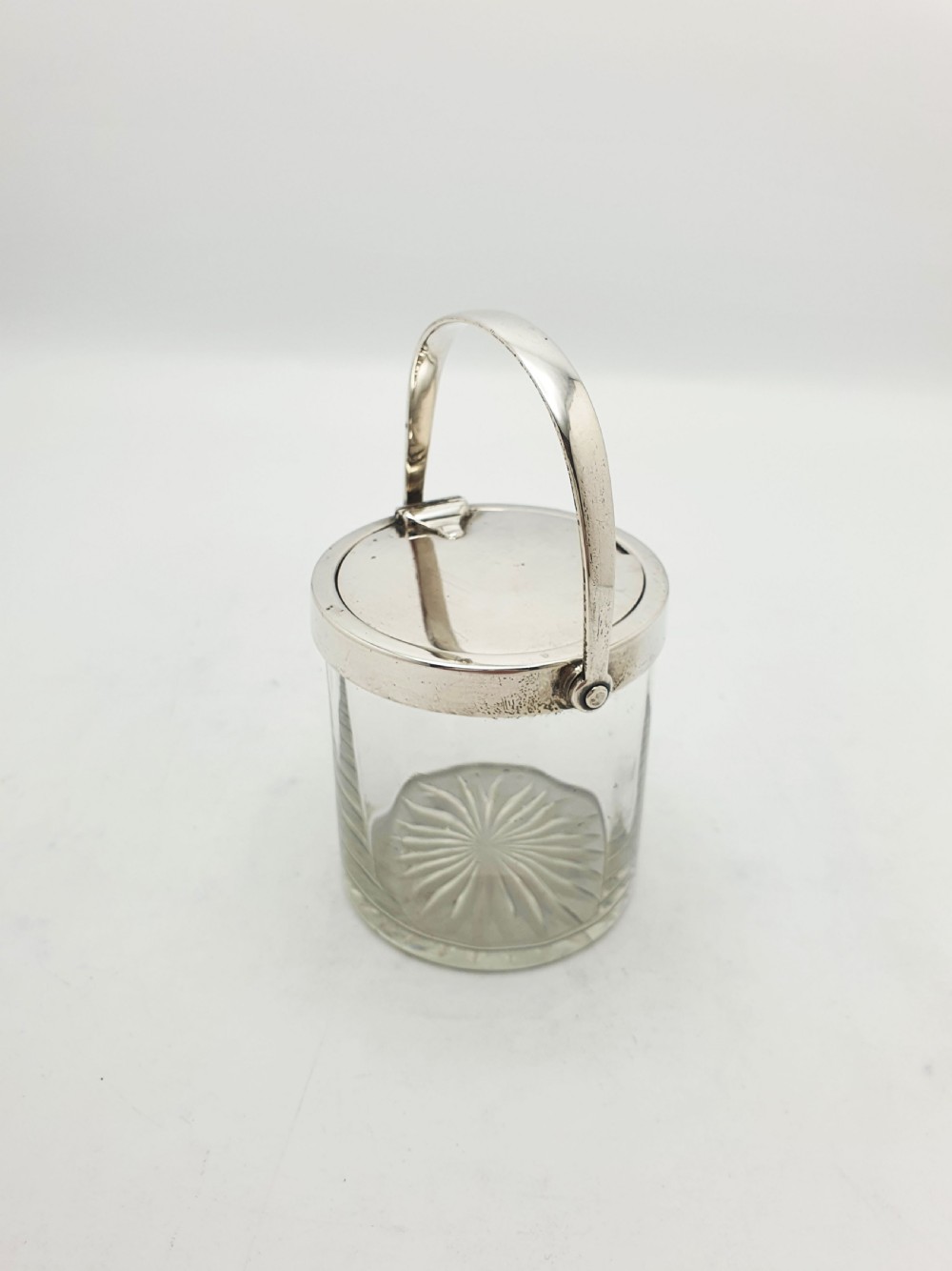 An antique cut glass condiment jar featuring a hallmarked sterling silver rim, swing handle, and hinged lid. View II