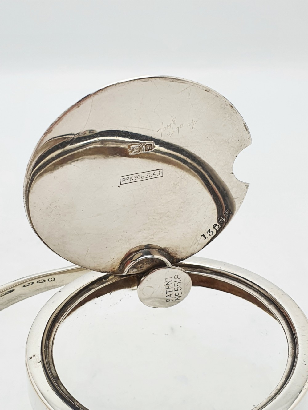An antique cut glass condiment jar featuring a hallmarked sterling silver rim, swing handle, and hinged lid. View III