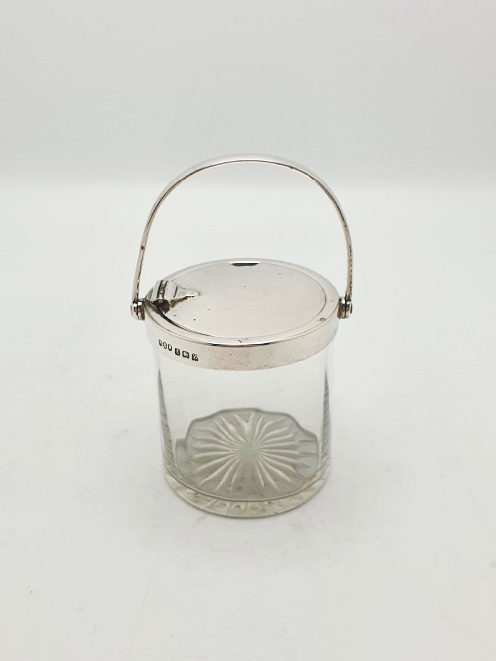 An antique cut glass condiment jar featuring a hallmarked sterling silver rim, swing handle, and hinged lid. View IV