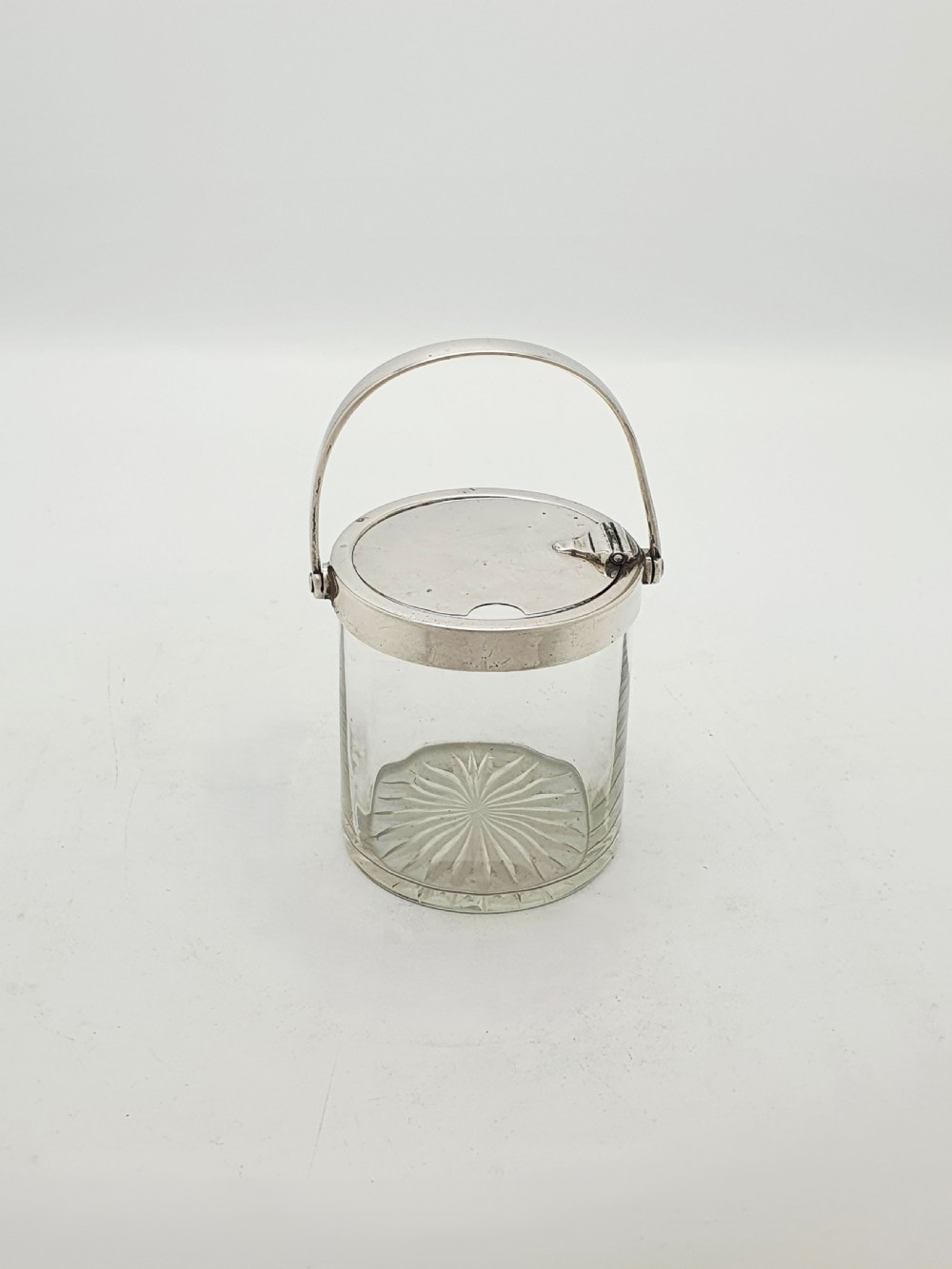 An antique cut glass condiment jar featuring a hallmarked sterling silver rim, swing handle, and hinged lid. View VII