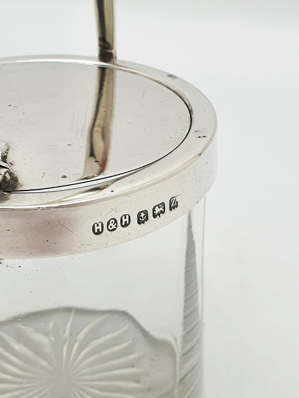 An antique cut glass condiment jar featuring a hallmarked sterling silver rim, swing handle, and hinged lid. View VIII