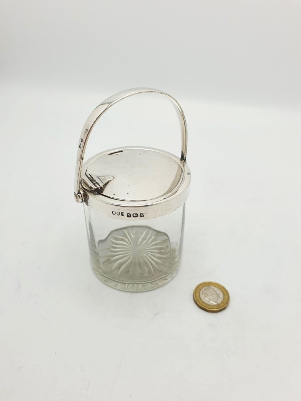 An antique cut glass condiment jar featuring a hallmarked sterling silver rim, swing handle, and hinged lid. View XI