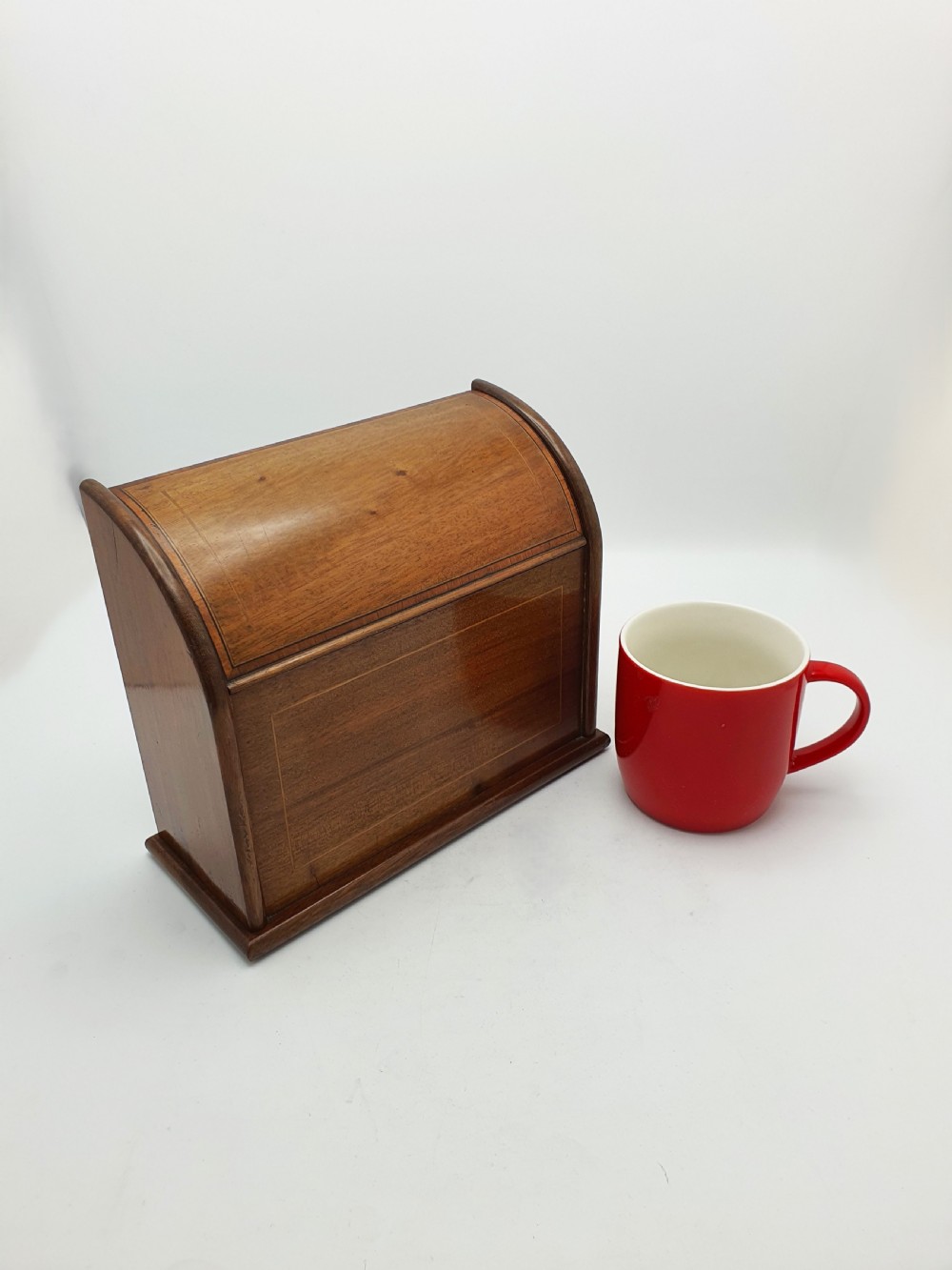 An antique Edwardian mahogany desk tidy featuring a hinged slanted lid, internal letter dividers, and line-inlaid boxwood detail on the front. View VIII