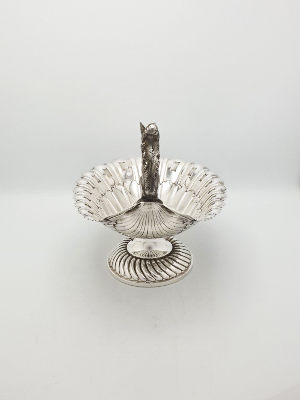 A silver-plated footed shell-shaped dish featuring a figurine of a squirrel perched on the rim holding an acorn, resting on a spiral-lobed pedestal base. View VII