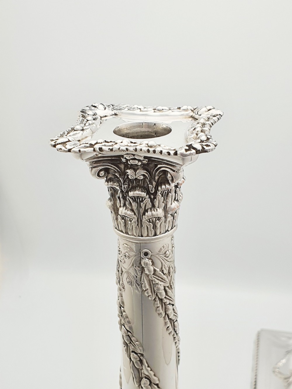 A pair of Victorian silver-plated candlesticks designed as Neoclassical Corinthian columns with spiral floral garlands and square beaded bases. View IX