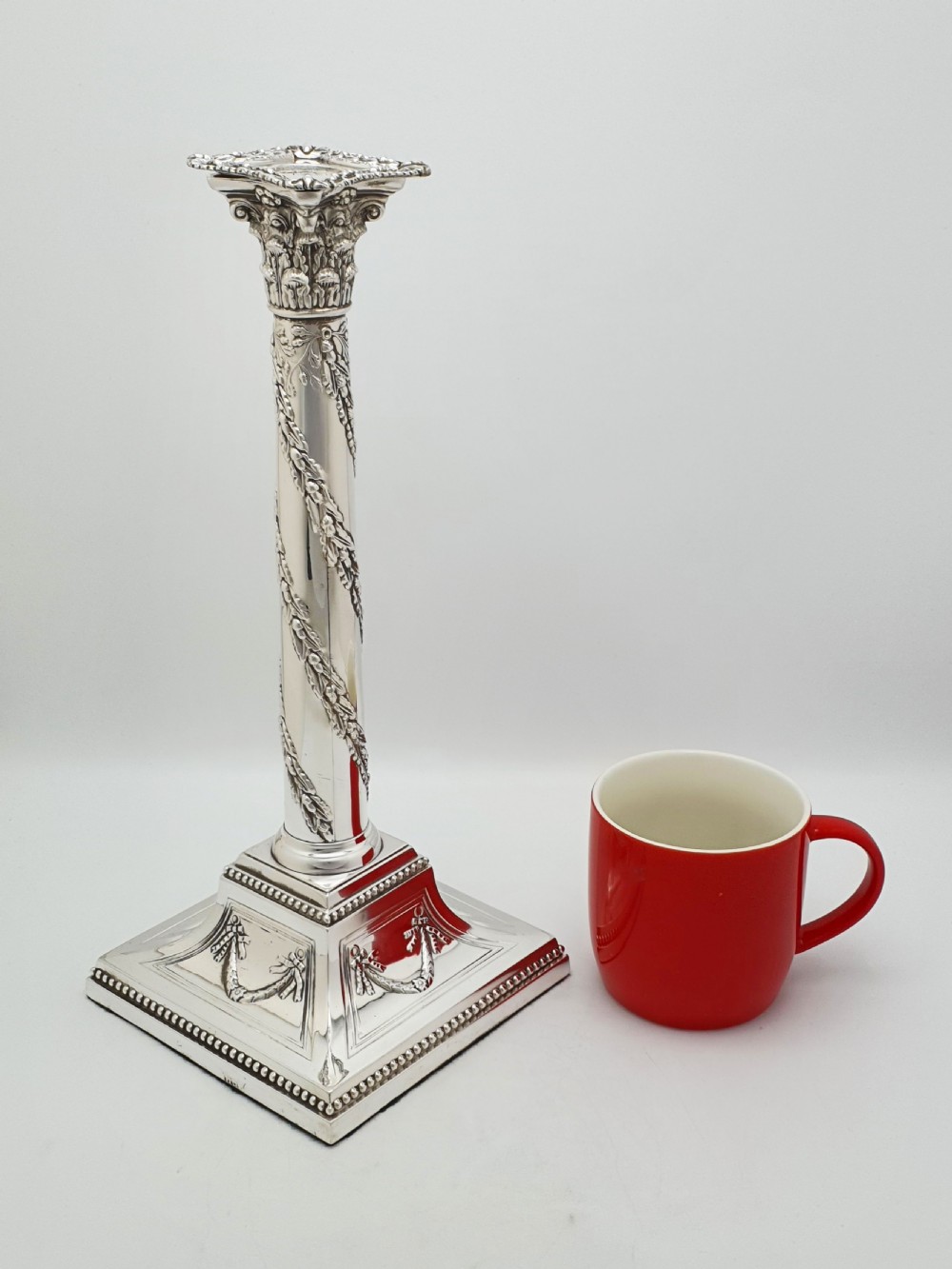 A pair of Victorian silver-plated candlesticks designed as Neoclassical Corinthian columns with spiral floral garlands and square beaded bases. View XI