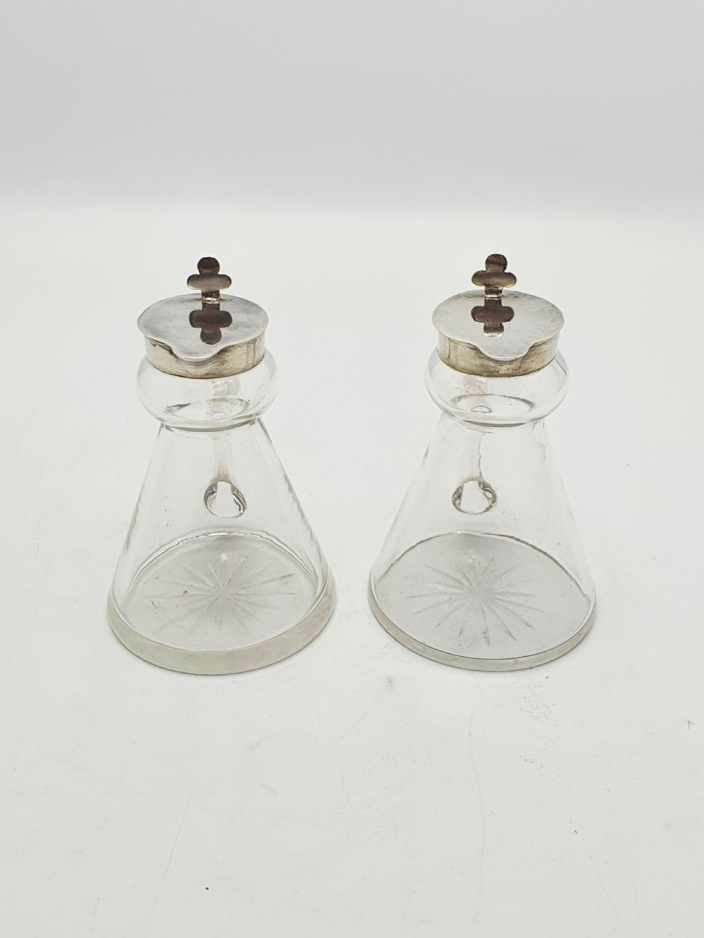 A pair of clear glass conical whiskey noggins with sterling silver collars, hinged lids, and applied glass loop handles. View VIII