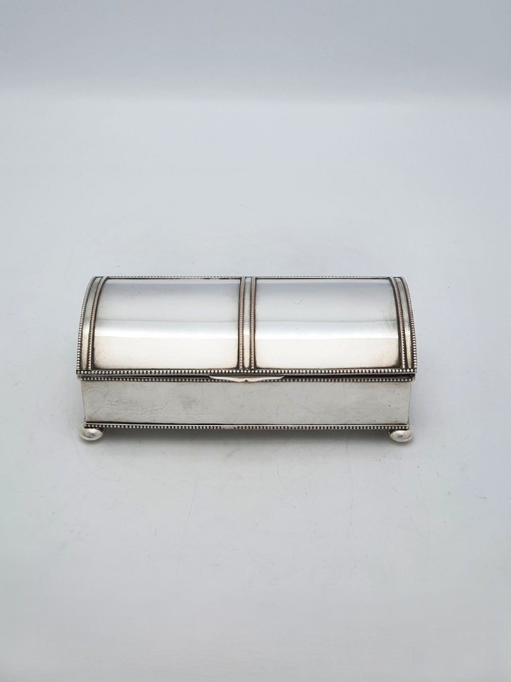 An Edwardian silver-plated rectangular inkstand box featuring a domed hinged lid, beaded border rims, and small ball feet. View II