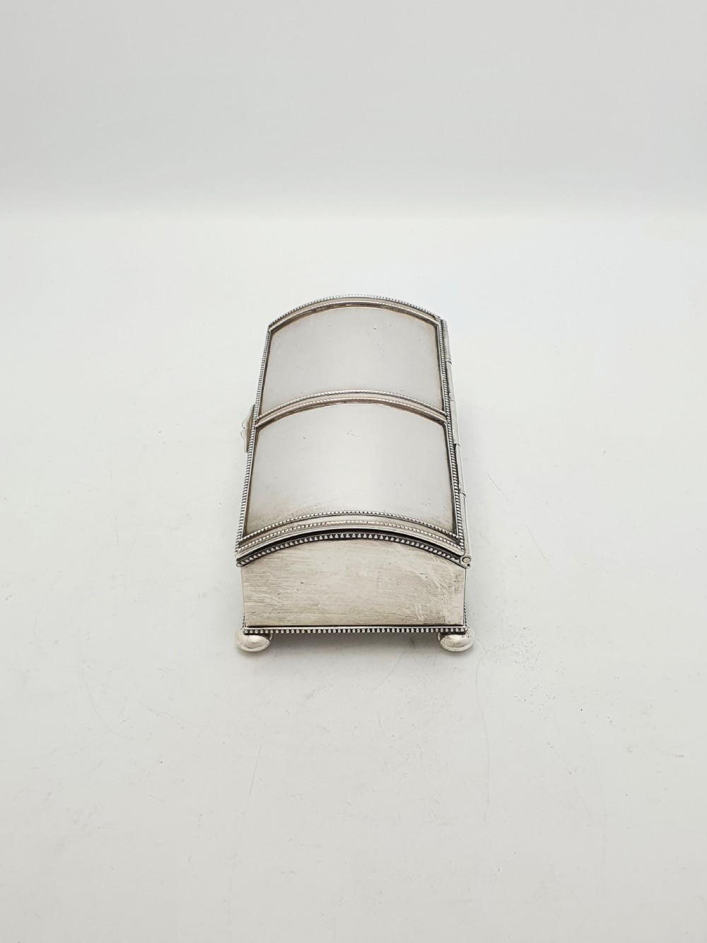 An Edwardian silver-plated rectangular inkstand box featuring a domed hinged lid, beaded border rims, and small ball feet. View VI