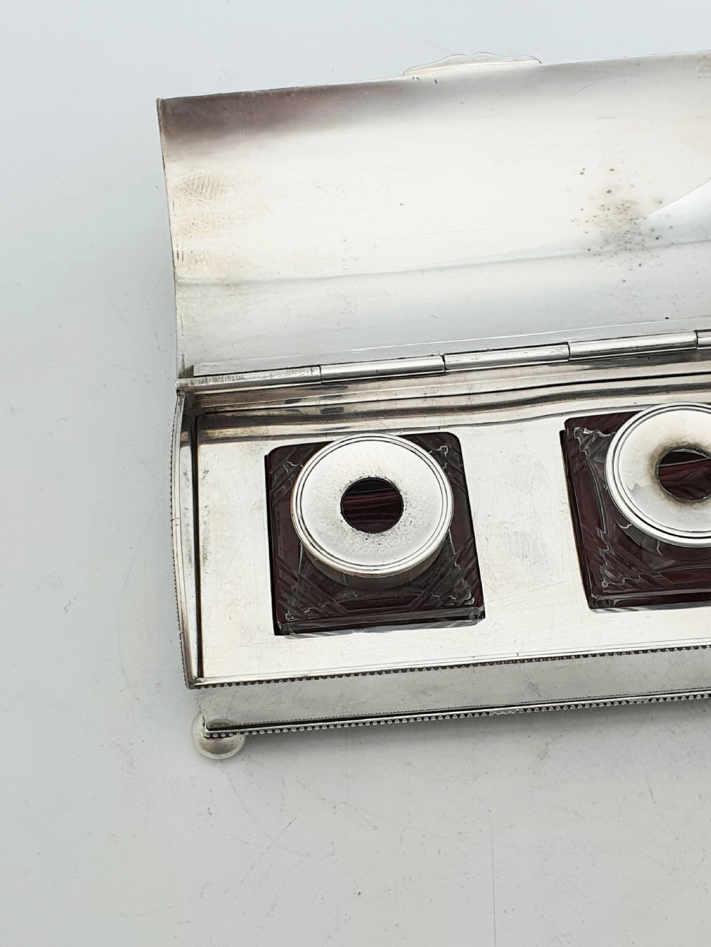 An Edwardian silver-plated rectangular inkstand box featuring a domed hinged lid, beaded border rims, and small ball feet. View XII
