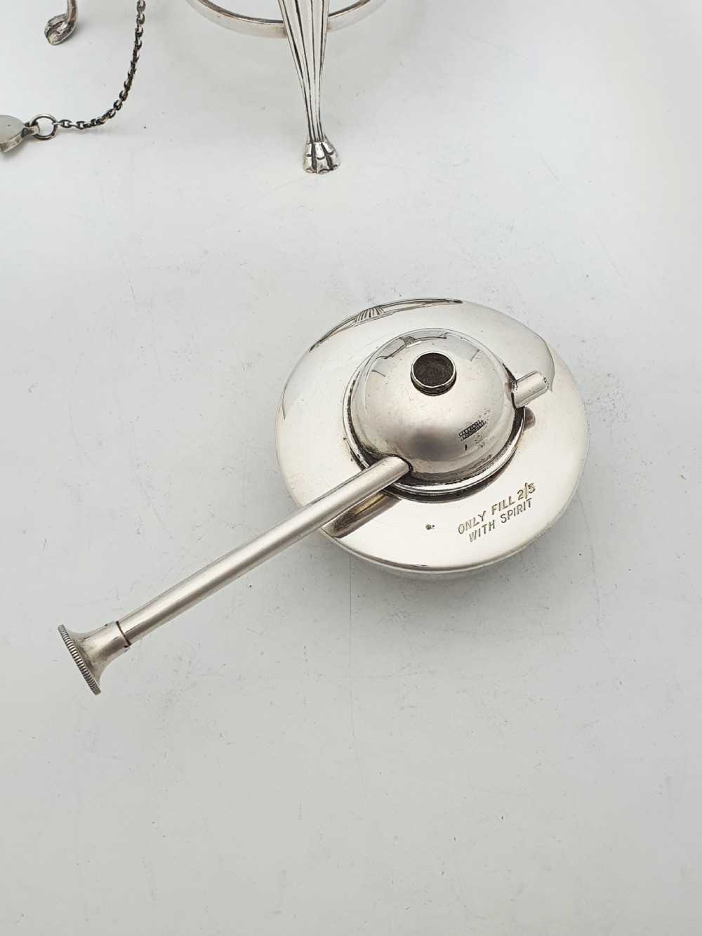An Edwardian silver-plated spirit kettle featuring a half-fluted lower body, an ebony handle grip, and a matching tripod stand with an alcohol burner. View VII