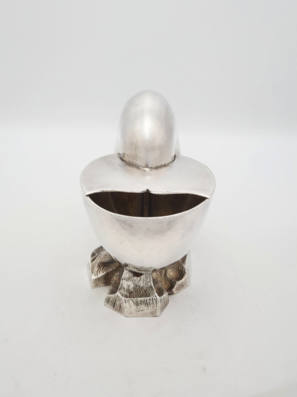 A Victorian silver-plated spoon warmer designed in the form of a nautilus shell mounted on a textured rocky base. View III
