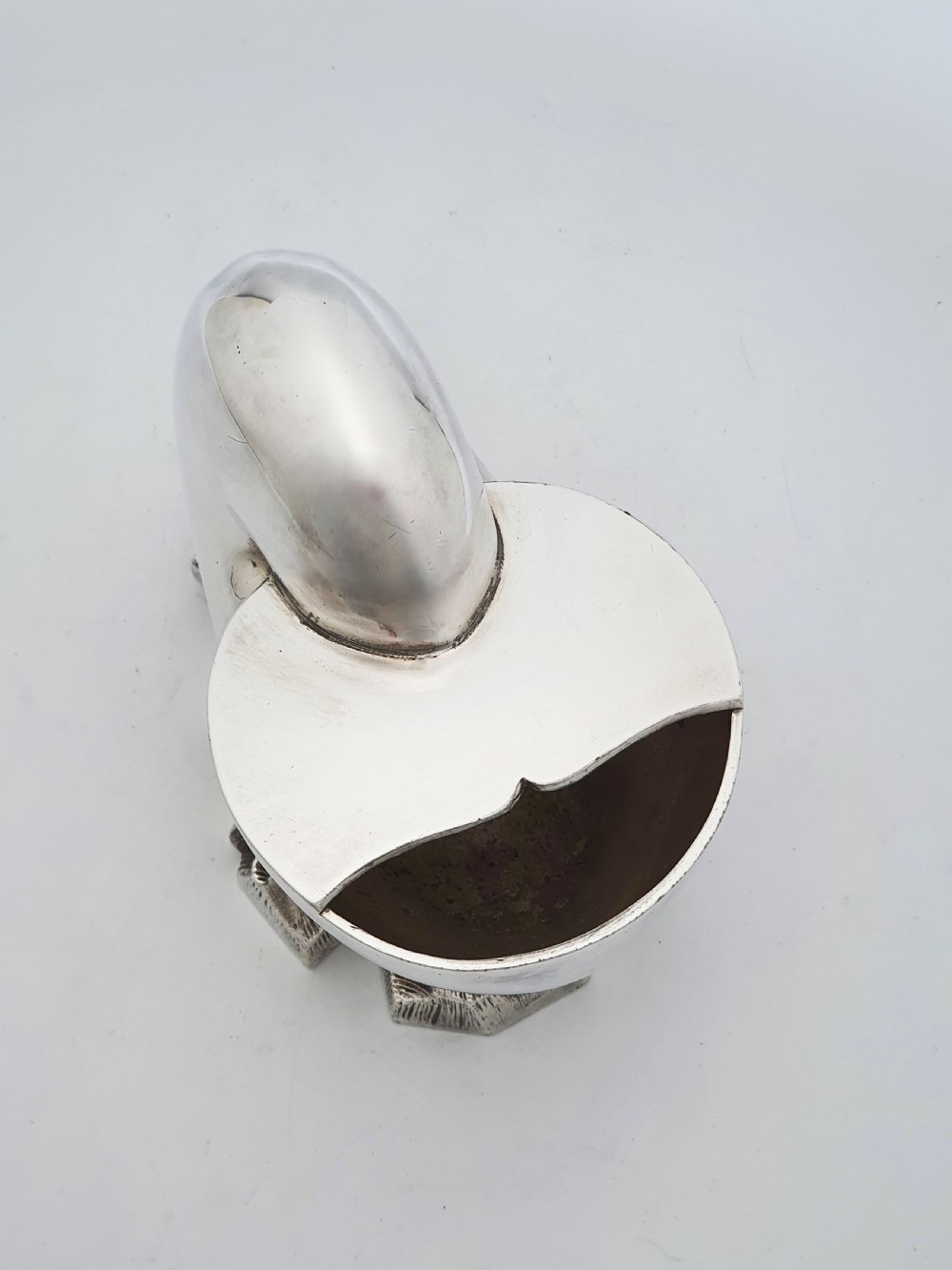 A Victorian silver-plated spoon warmer designed in the form of a nautilus shell mounted on a textured rocky base. View V