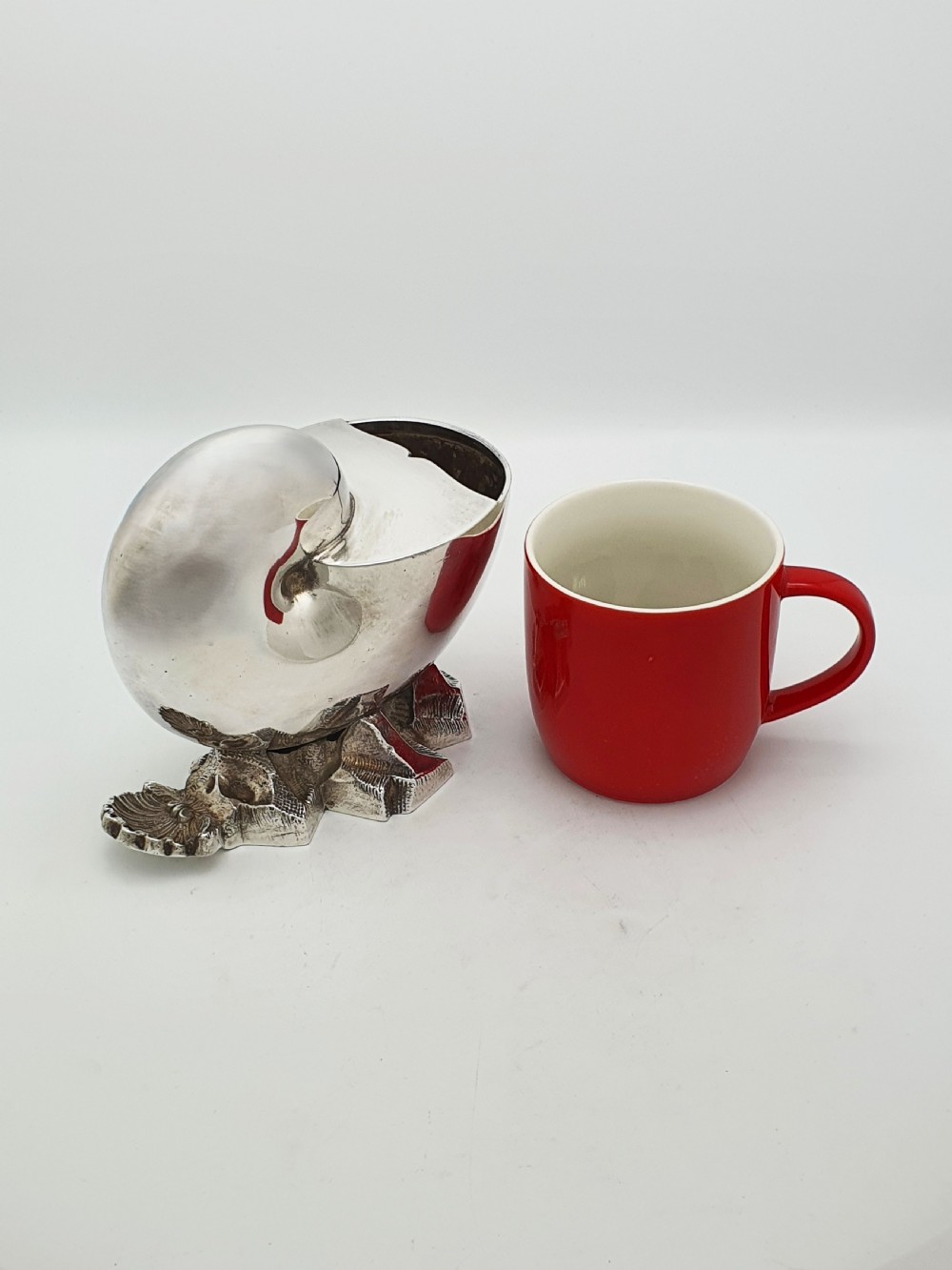 A Victorian silver-plated spoon warmer designed in the form of a nautilus shell mounted on a textured rocky base. View VI
