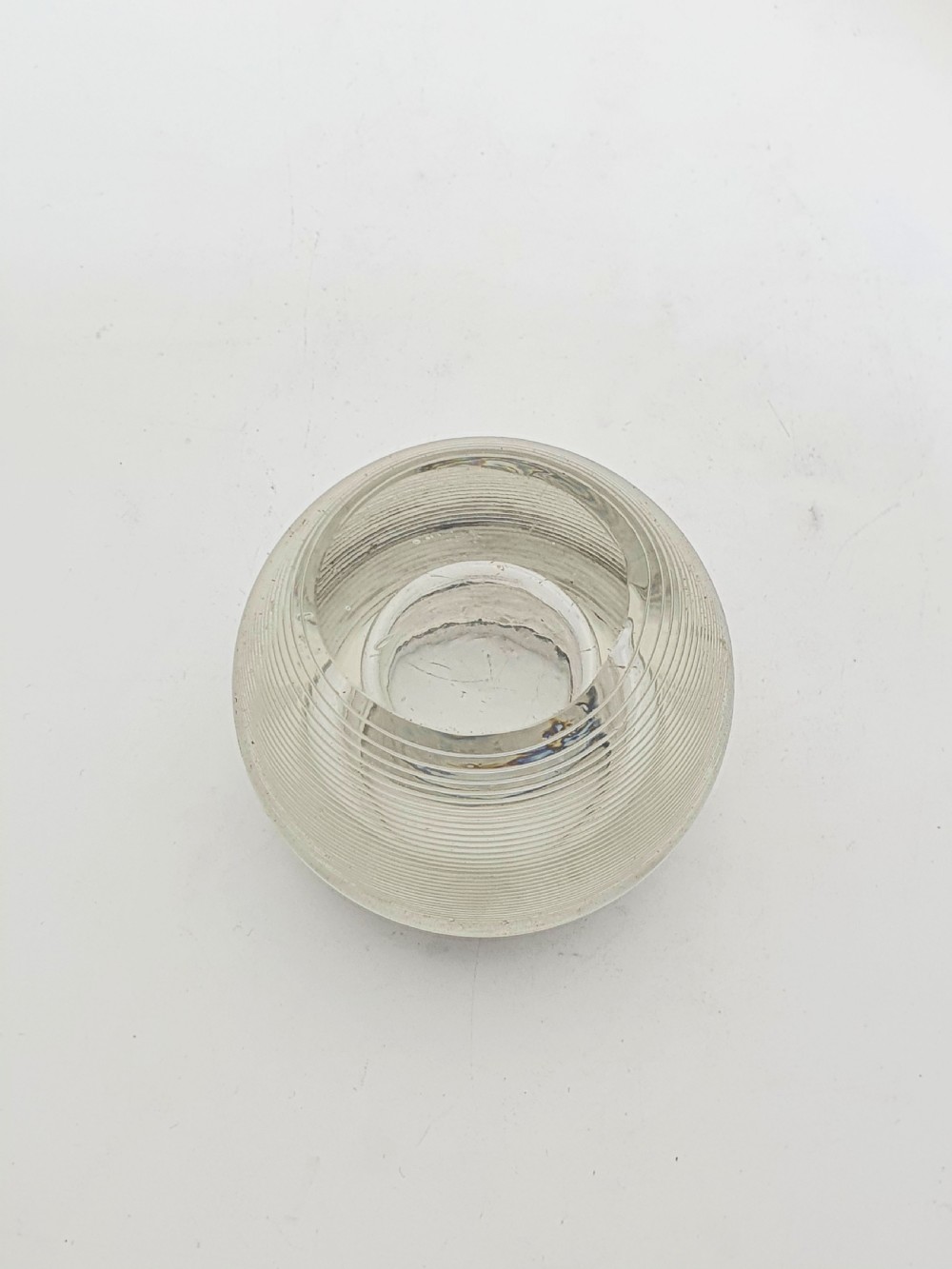 A spherical clear ribbed glass match striker featuring a hallmarked sterling silver collar around the top rim. View III