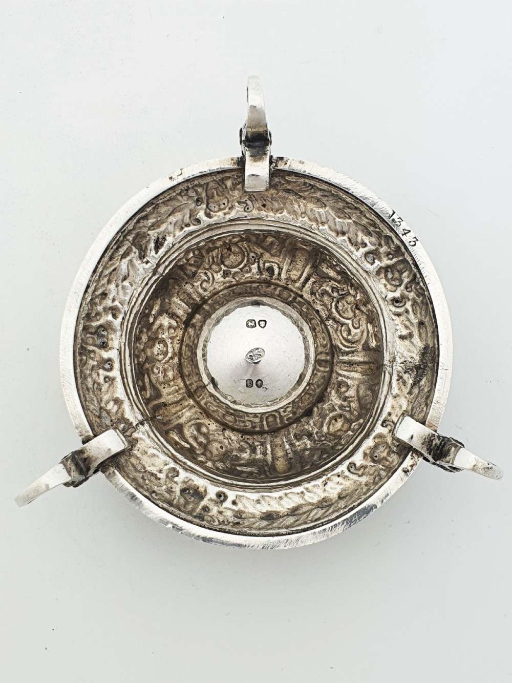 A pair of Victorian sterling silver salt cellars decorated with chased classical masks, foliate wreaths, and tripod feet. View VII