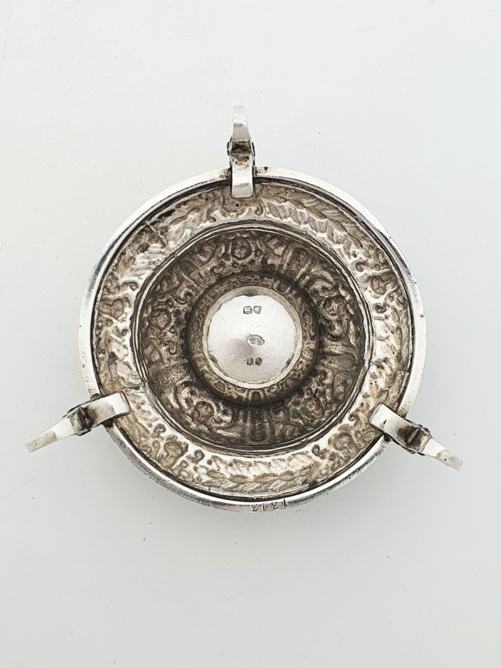 A pair of Victorian sterling silver salt cellars decorated with chased classical masks, foliate wreaths, and tripod feet. View IX