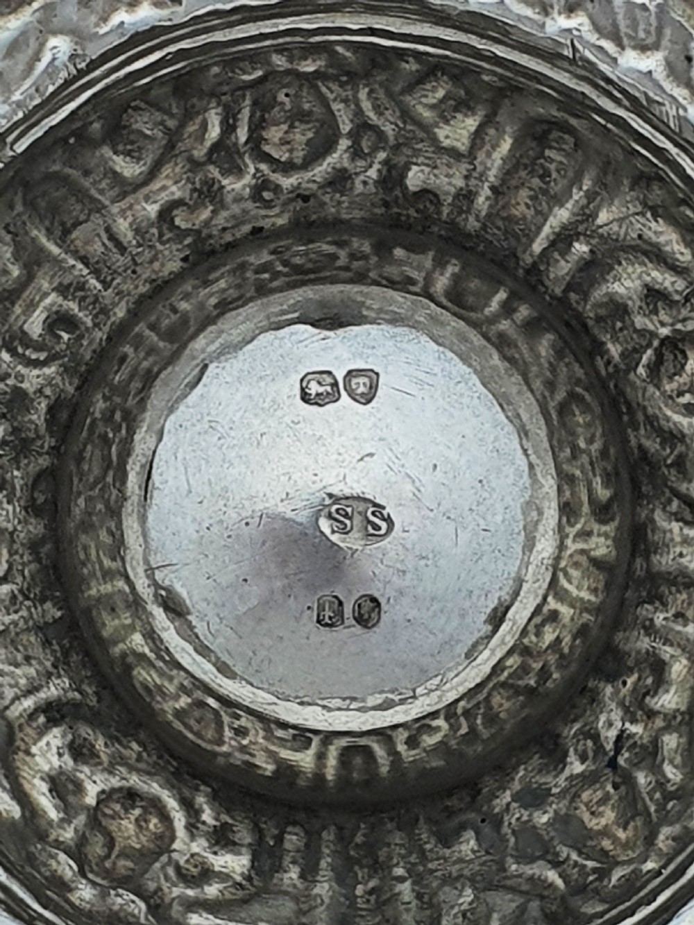 A pair of Victorian sterling silver salt cellars decorated with chased classical masks, foliate wreaths, and tripod feet. View X