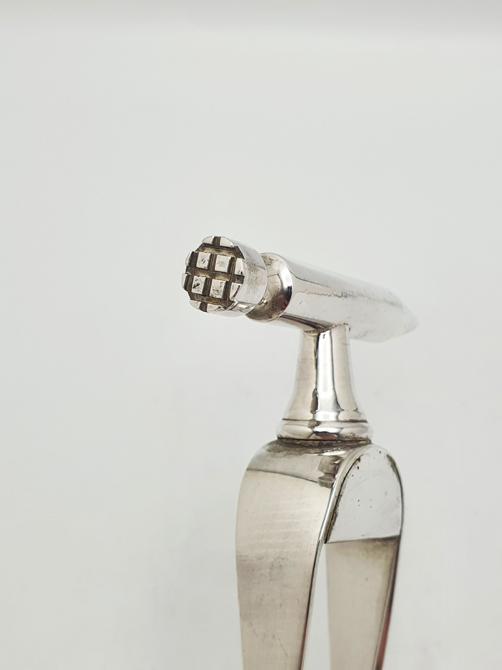 A pair of silver-plated Art Deco ice tongs featuring bird claw grippers and a top-mounted ice pick hammer head. View V