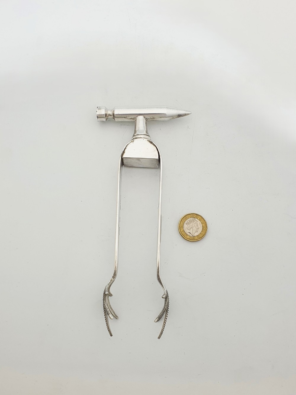 A pair of silver-plated Art Deco ice tongs featuring bird claw grippers and a top-mounted ice pick hammer head. View VIII