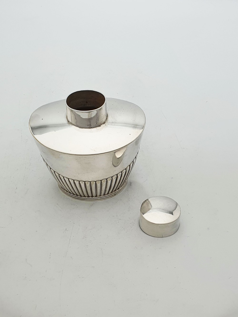 An Edwardian silver-plated tea canister featuring fluted body decoration and a fitted push-on lid. View III