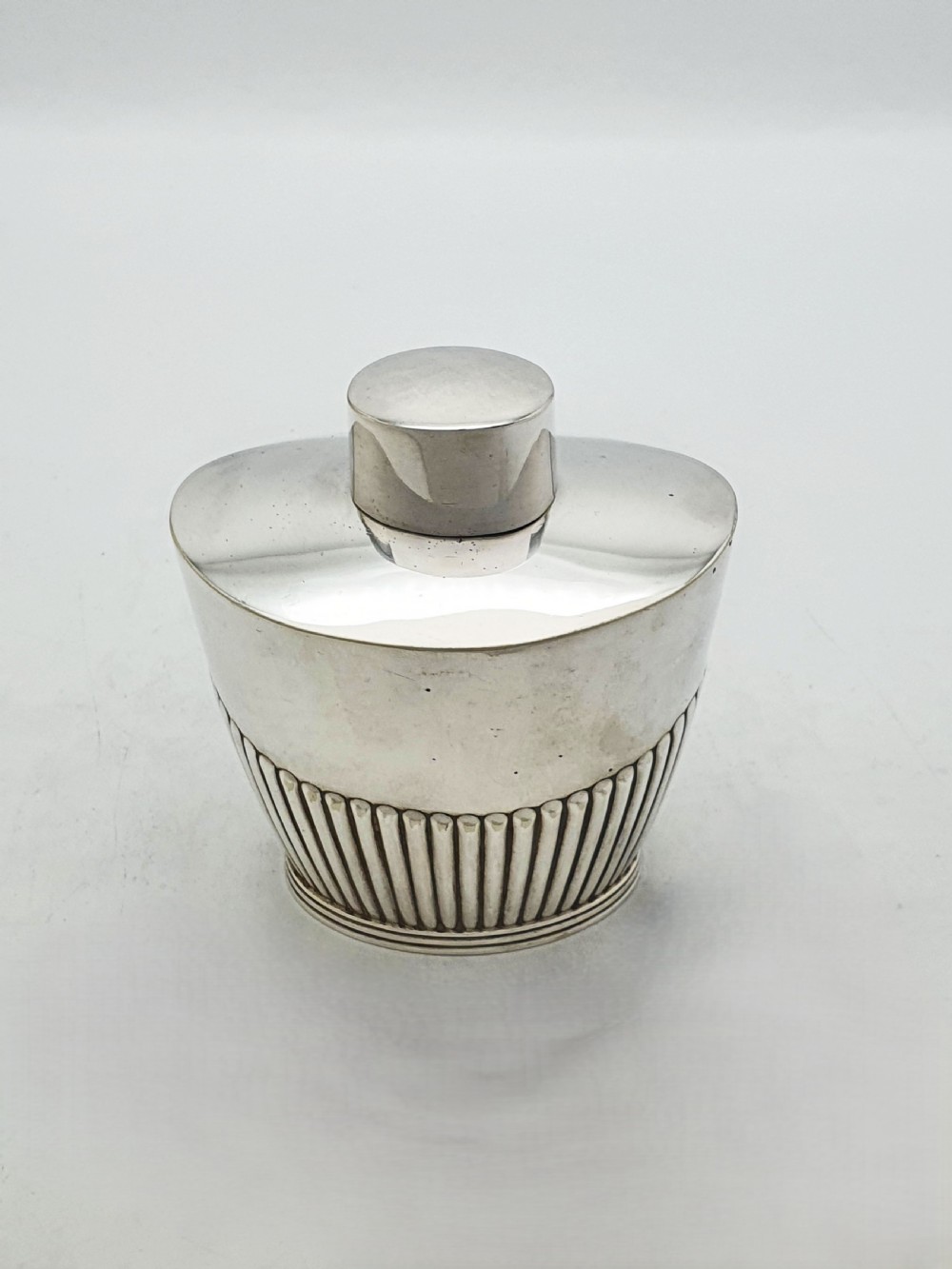 An Edwardian silver-plated tea canister featuring fluted body decoration and a fitted push-on lid. View VI