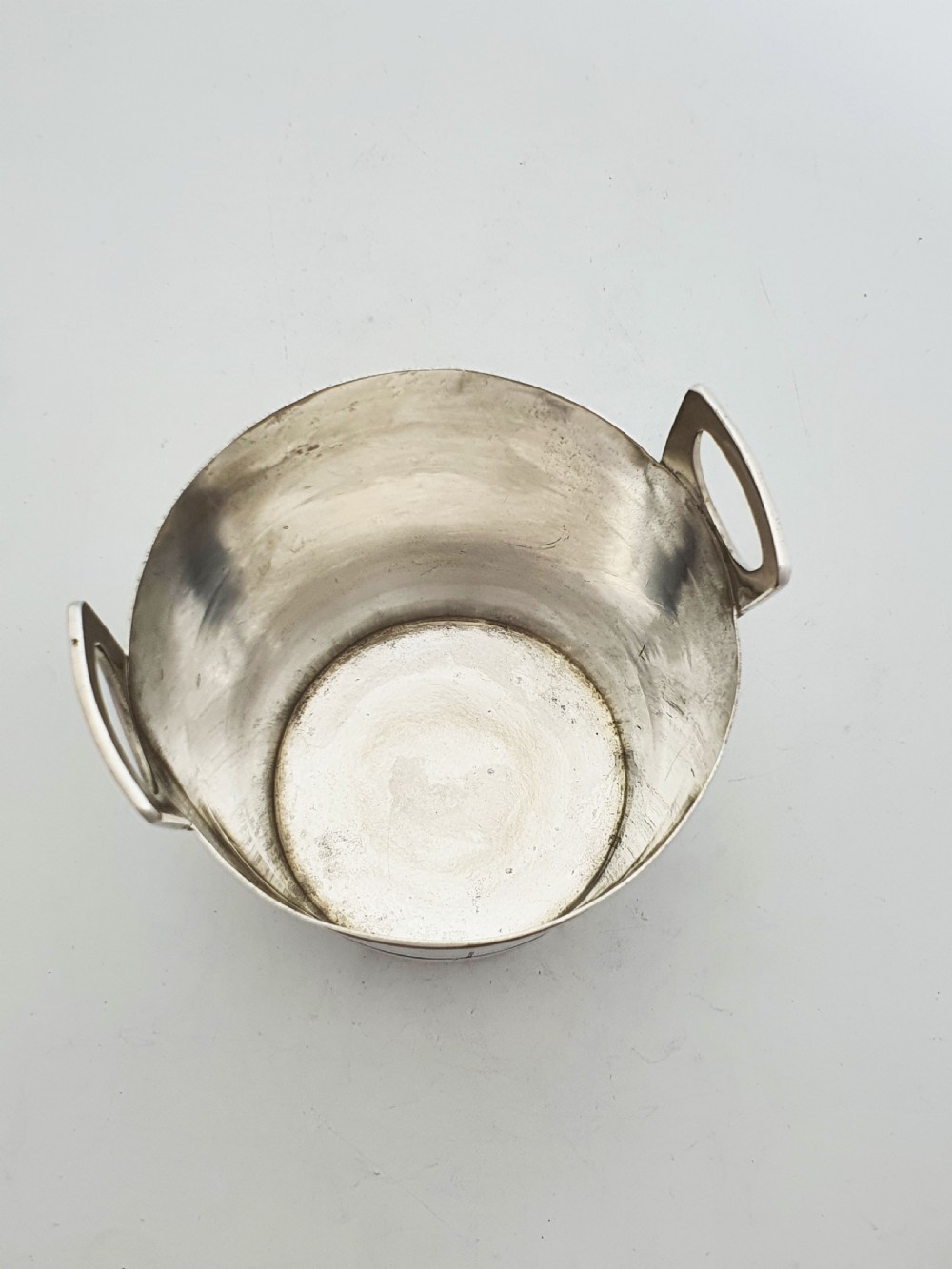 An Edwardian silver-plated ice bucket shaped like a wooden barrel with integrated handles alongside matching claw-foot ice tongs. View VII
