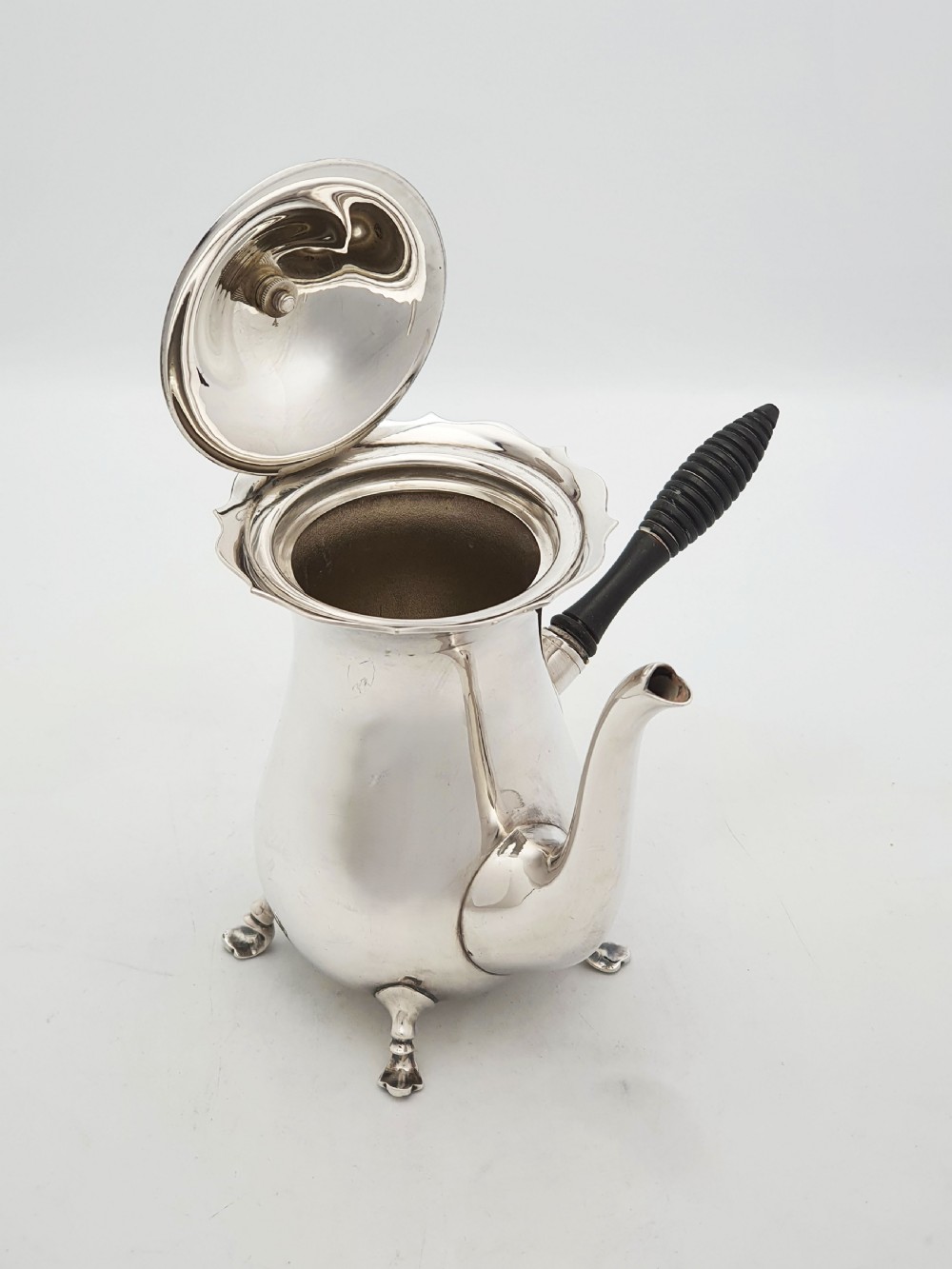 A pair of Edwardian silver cafe au lait pots featuring ribbed wooden side handles, scalloped hinged lids, and carved cabriole feet. View II