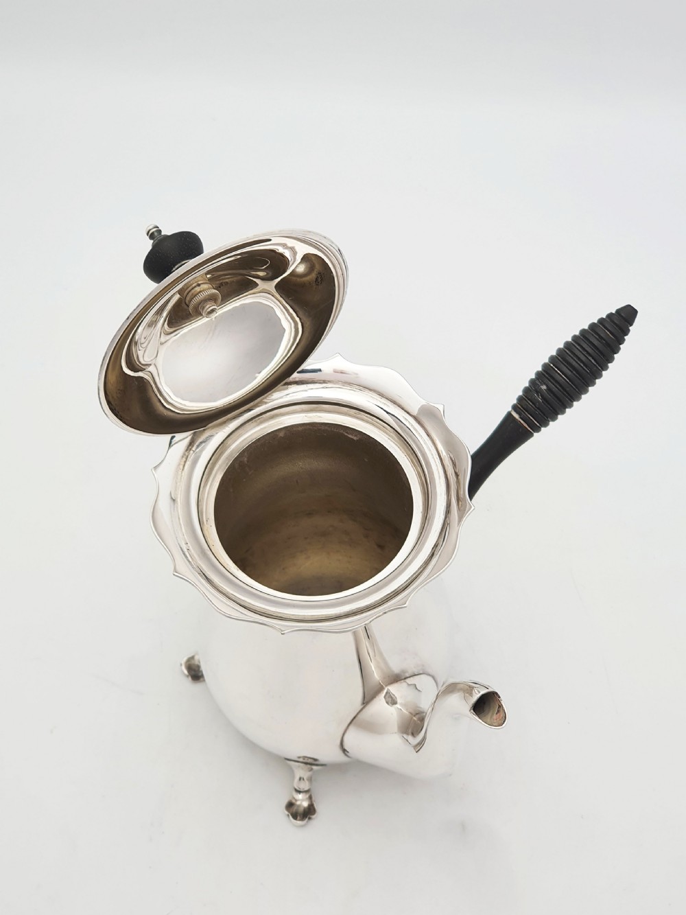 A pair of Edwardian silver cafe au lait pots featuring ribbed wooden side handles, scalloped hinged lids, and carved cabriole feet. View III