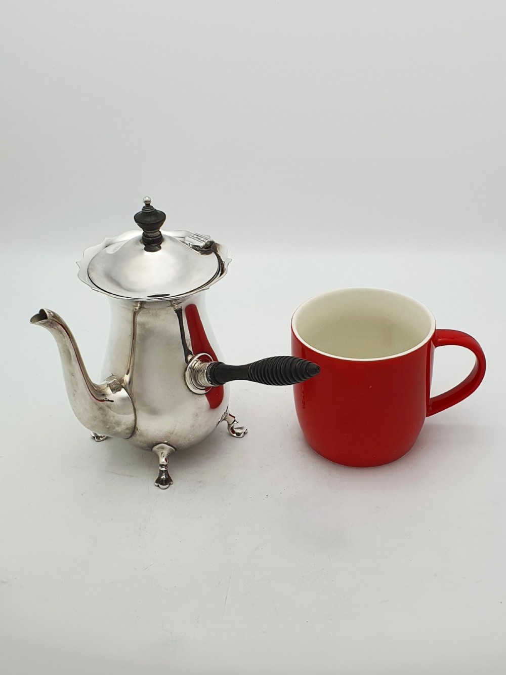 A pair of Edwardian silver cafe au lait pots featuring ribbed wooden side handles, scalloped hinged lids, and carved cabriole feet. View XI