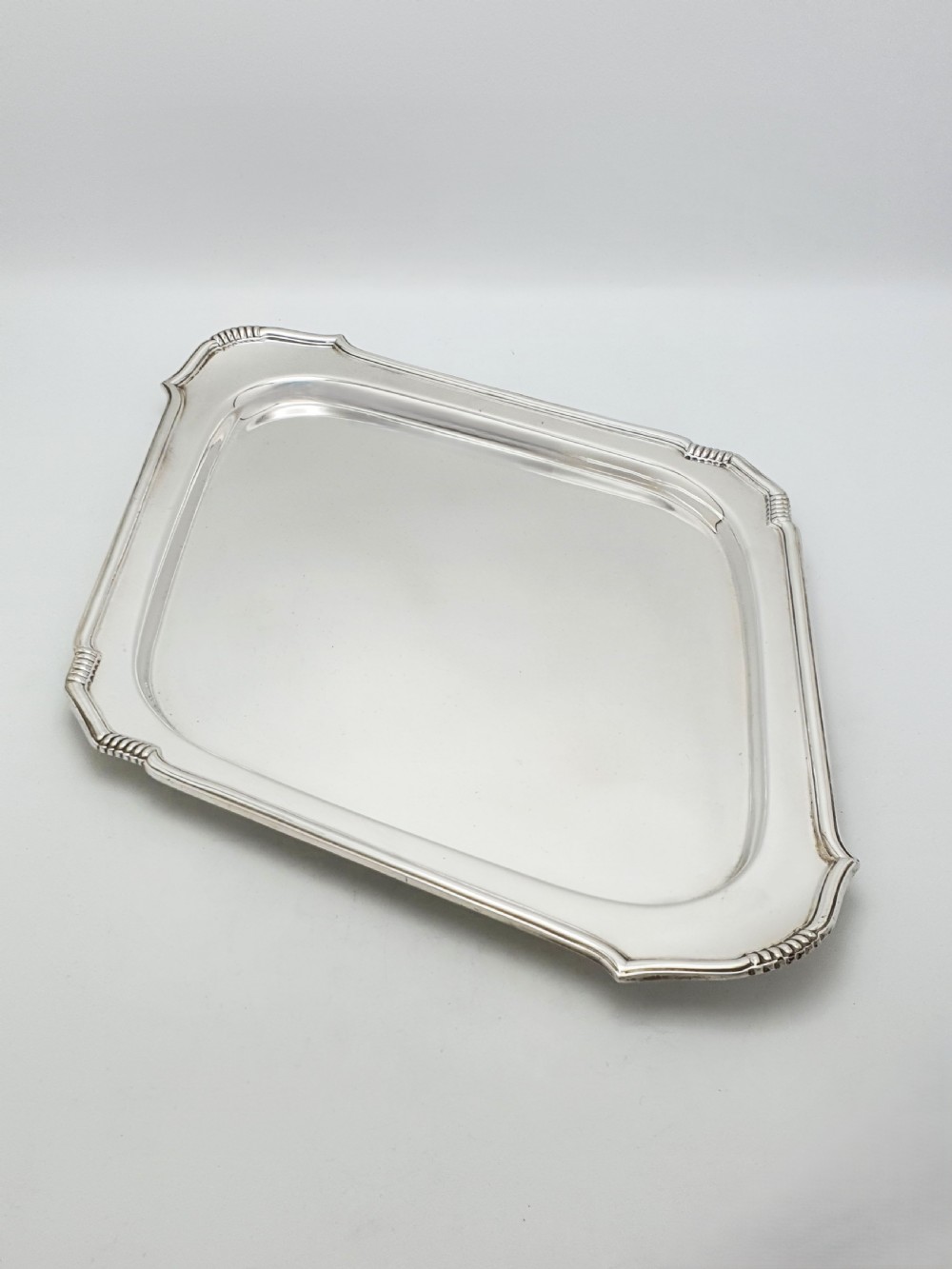 An Art Deco silver-plated serving tray featuring a geometric diamond shape with reeded detailing along the raised rim.