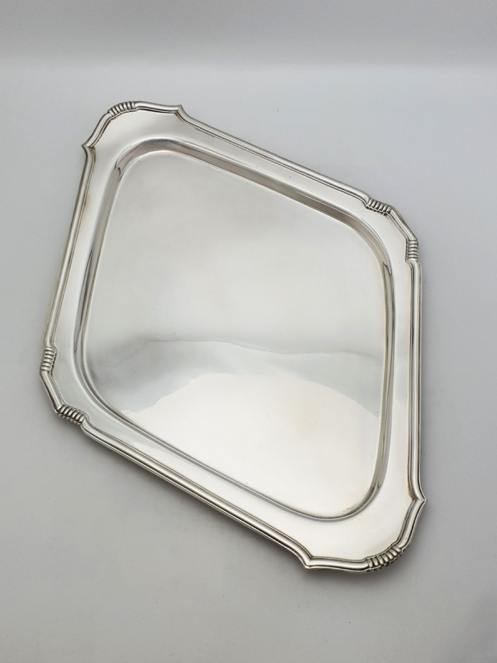 An Art Deco silver-plated serving tray featuring a geometric diamond shape with reeded detailing along the raised rim. View II