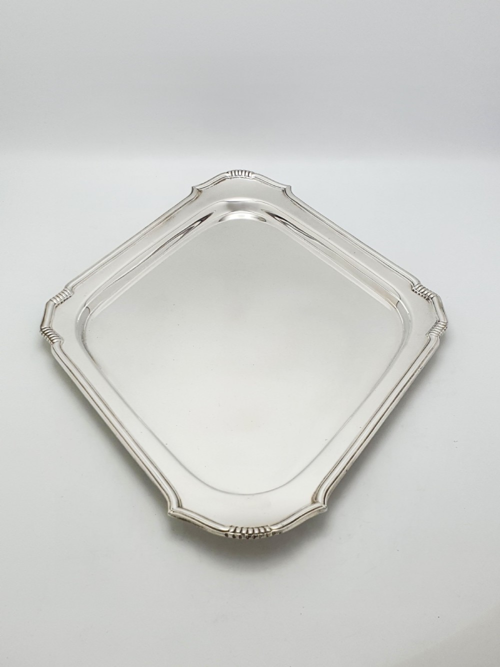 An Art Deco silver-plated serving tray featuring a geometric diamond shape with reeded detailing along the raised rim. View III