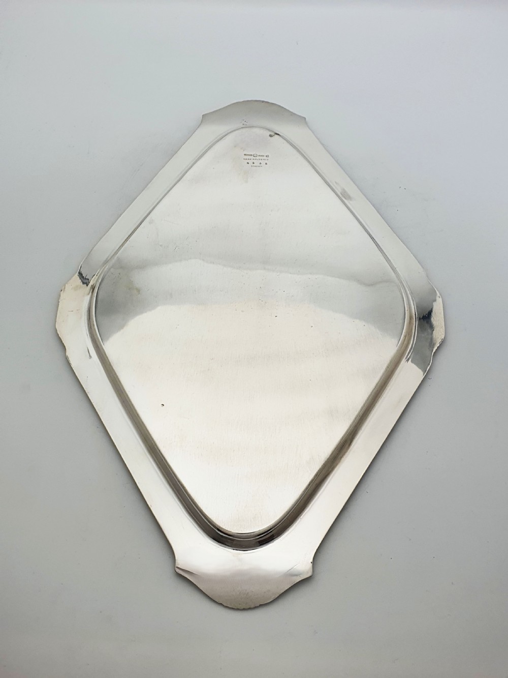 An Art Deco silver-plated serving tray featuring a geometric diamond shape with reeded detailing along the raised rim. View V