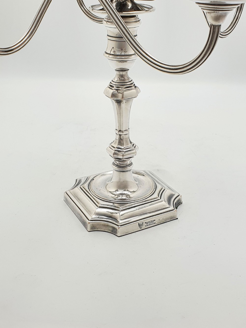 An Edwardian silver-plated five-light candelabrum featuring curved scrolling arms, urn-form sconces, a removable flame finial, and a stepped square base. View VI