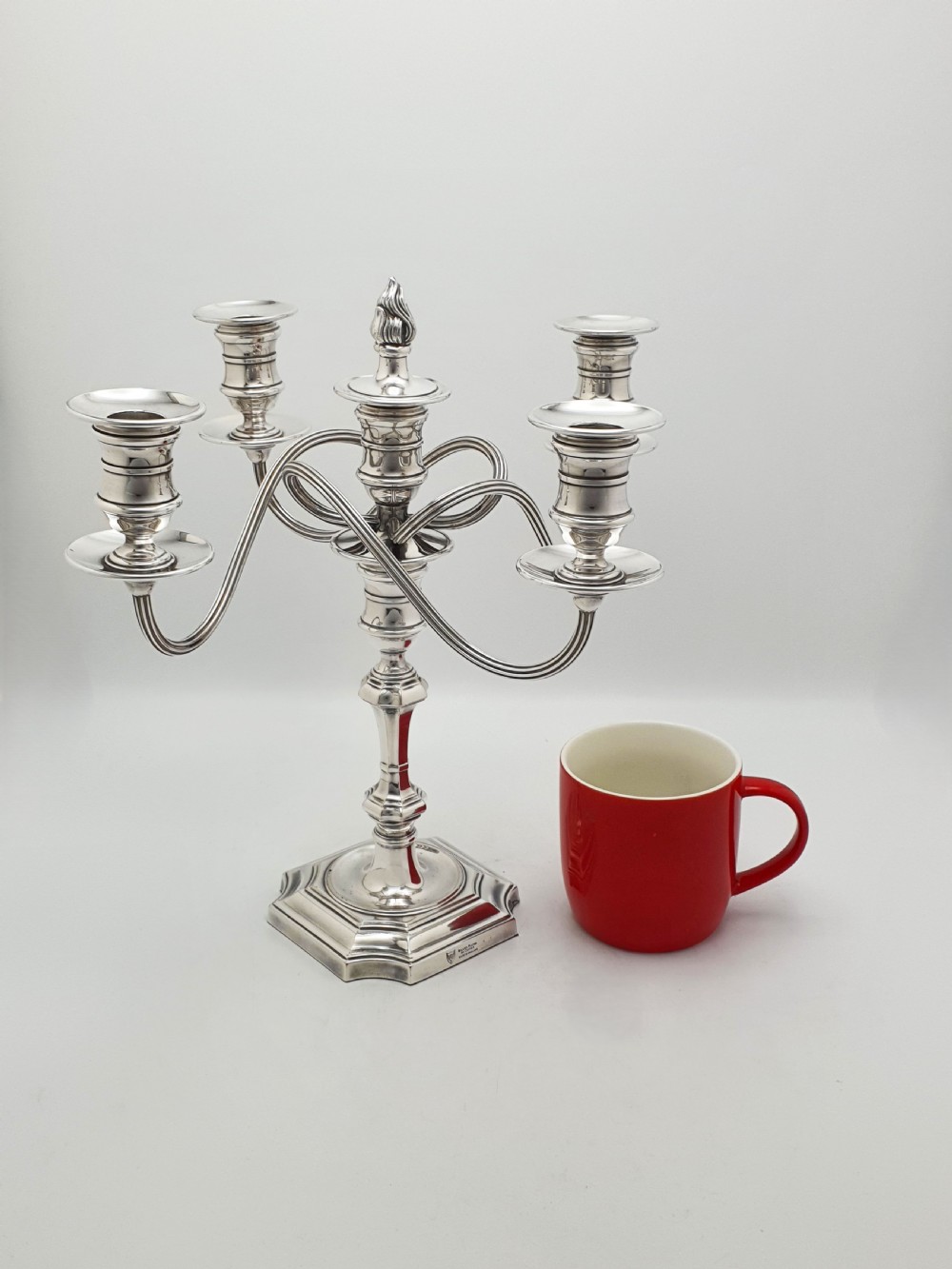 An Edwardian silver-plated five-light candelabrum featuring curved scrolling arms, urn-form sconces, a removable flame finial, and a stepped square base. View VII