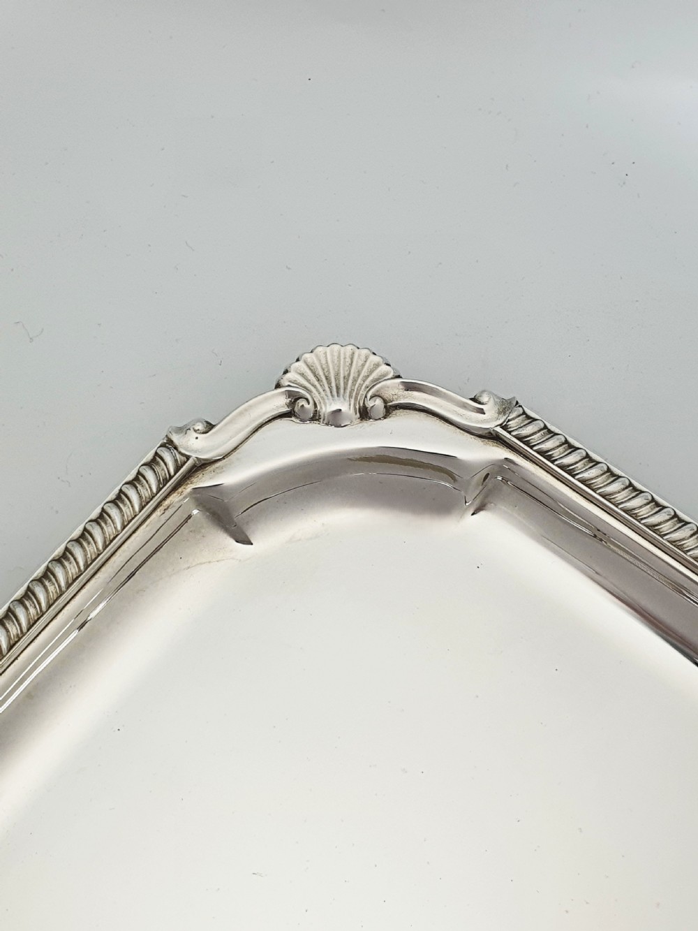 A square silver-plated cocktail tray featuring moulded shell motifs at the four corners and a gadrooned rim border. View II